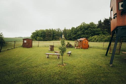 a garden with a bench and a tree in the grass at Posed Rikitan in Spálené Poříčí