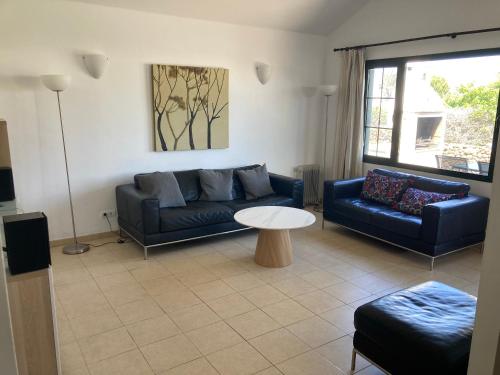 a living room with a couch and a table at Casa Palmeras, Punta Limones, Playa Blanca, Lanzarote in Playa Blanca