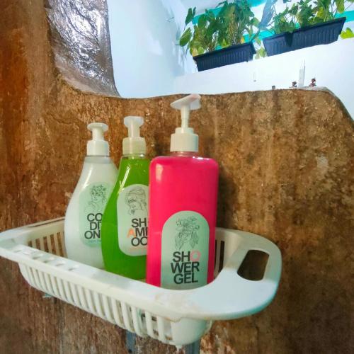 three bottles of detergent sitting in a basket at Palm Sunrise in Diani Beach