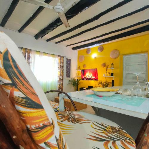 a living room with a table and a chair at Palm Sunrise in Diani Beach