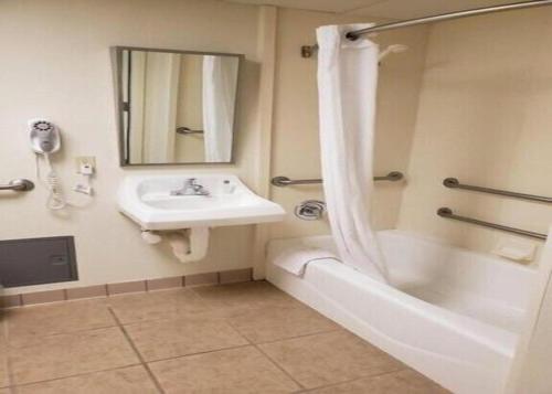 a bathroom with a sink and a tub and a shower at Motel 6 Hastings NE in Hastings