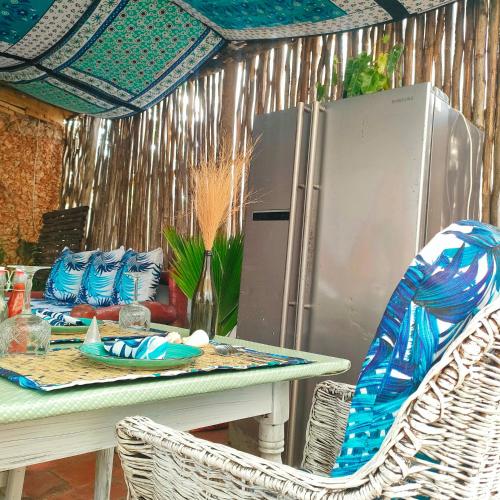 a table with chairs and a refrigerator in a kitchen at Palm Sunrise in Diani Beach