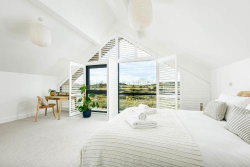 a white bedroom with a bed and a desk at Everdene OI14 Lakeside Property with Hot Tub at Silverlake Dorset in Warmwell