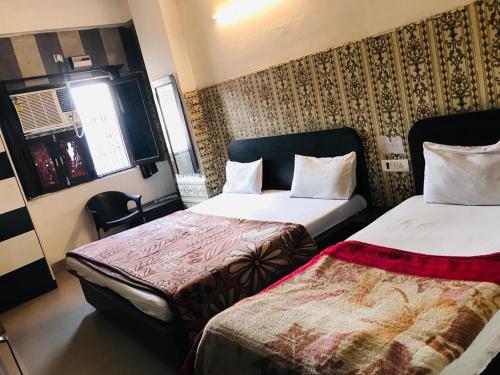 a hotel room with two beds and a window at A budget hotel sheeva palace near tulshi chowk in Haridwār