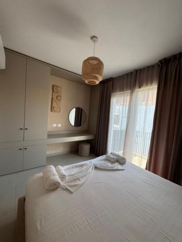 a bedroom with a bed with towels on it at The Azure Breeze Beachfront Escape in Golem