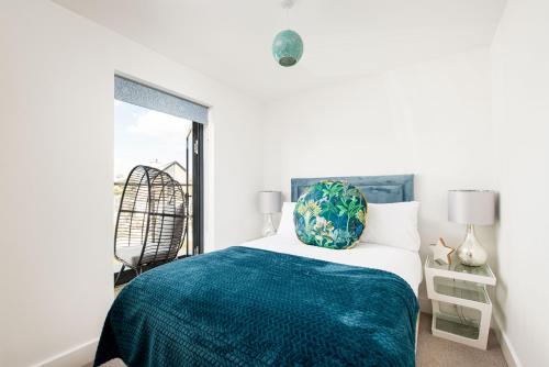 ein Schlafzimmer mit einem Bett mit einer grünen Decke und einem Fenster in der Unterkunft Cosy Cottage OI31 Silverlake Dorset in Warmwell