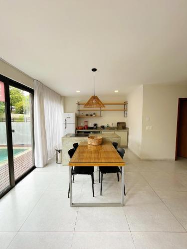 a kitchen and dining room with a wooden table at Fontes da Pipa by Liiv in Pipa