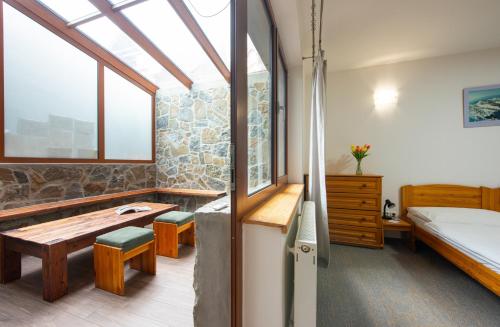 a bedroom with a bed and a table and a window at Penzion Snezienka in Tatranská Lomnica
