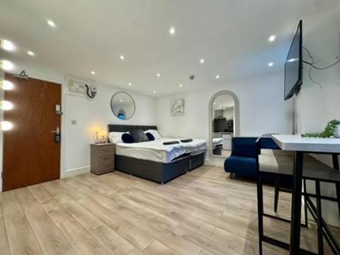 a bedroom with a bed and a blue couch at Canal Walk Studio Apartments in Southampton