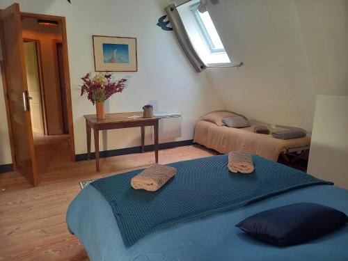 - une chambre avec 2 lits et une table avec des serviettes dans l'établissement Chambres d'hôtes à 2 km de veules les Roses, à Angiens