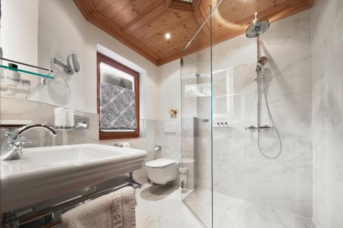 a bathroom with a shower and a sink and a toilet at Relais & Châteaux Hotel Tennerhof in Kitzbühel