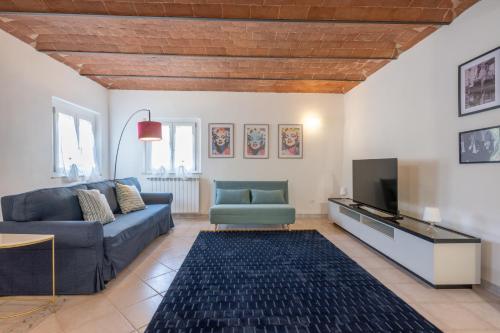 a living room with a couch and a tv at Arno Breeze – Casa Manin in Calcinaia