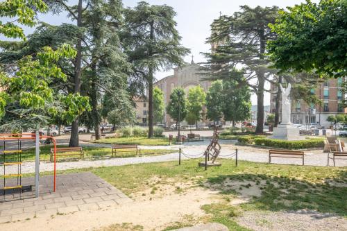 a park with benches and a statue in front of a building at Arno Breeze – Casa Manin in Calcinaia
