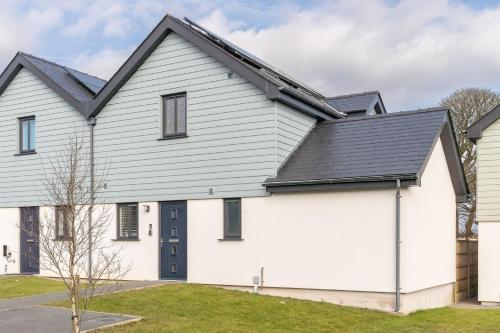 a white house with a black roof at 5 Parc Delfryn in Benllech