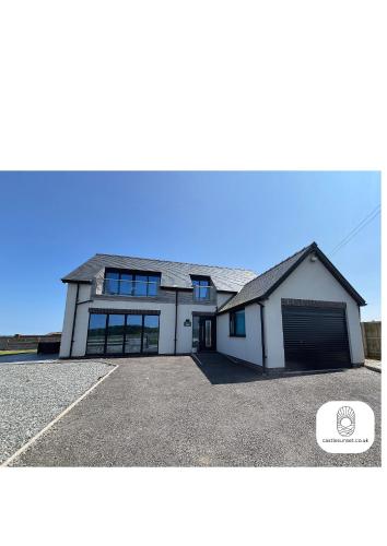 a large white building with a garage at Luxury 4-Bedroom Beachfront Home with Hot Tub & Games Room in Cayton