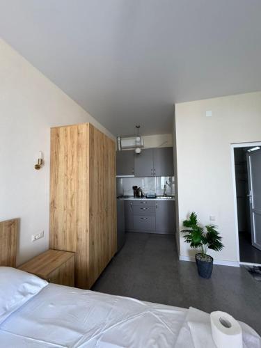 a bedroom with a white bed and a kitchen at nira hotel in Gonio