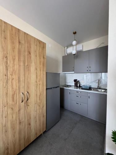 a kitchen with stainless steel appliances and wooden cabinets at nira hotel in Gonio