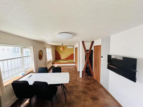 a living room with a white table and chairs at Yoshinaga B&B Snow in Sapporo