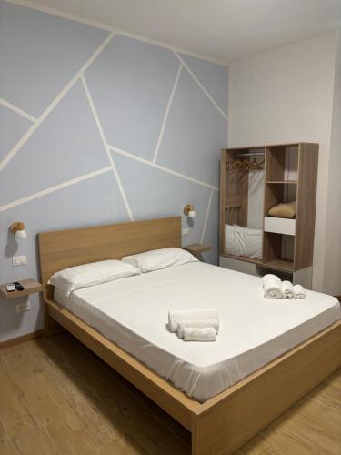 a bedroom with a bed with white sheets and towels at Le tre Vele in La Spezia