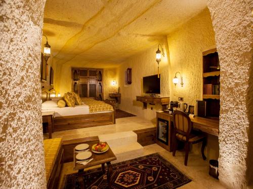 a room with a bedroom with a bed and a fireplace at Kayakapi Premium Caves Cappadocia in Urgup