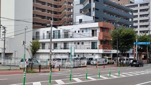 a city street with cars parked in front of a building at Vivo House Hakomatsu - Apartment Stay in Fukuoka
