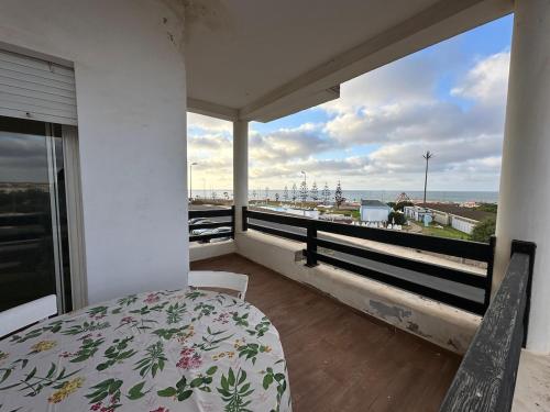 a bedroom with a bed and a view of the ocean at Beach flat with pool at Al Mansouria in O Ben Slimane