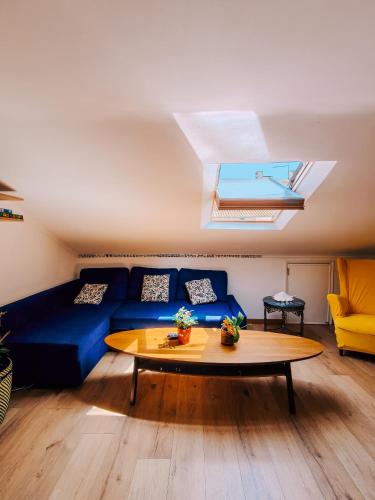 a living room with a blue couch and a table at Lisbon Soul Surf Camp in Cascais