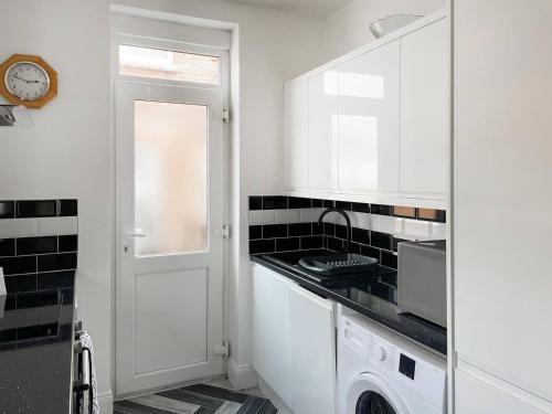 cocina blanca con fogones horno de arriba junto a una puerta en 2BR Filey Flat, Near Seafront - Perfect for Getaways, en Filey