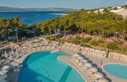 an overhead view of a pool with chairs and umbrellas at Bluesun Hotel Elaphusa in Bol