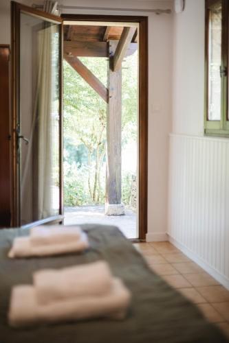 trois serviettes pliées posées sur un lit devant une porte dans l'établissement Domaine de Malet, à Vitrac