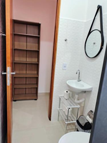 a bathroom with a sink and a mirror at Suíte Da Rosa in Cachoeira Paulista