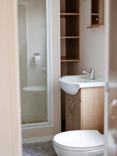 a bathroom with a toilet and a sink at Domki Nad Morzem IDPB in Gąski