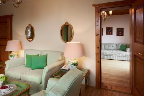 a living room with a couch and a chair at Relais & Châteaux Hotel Tennerhof in Kitzbühel