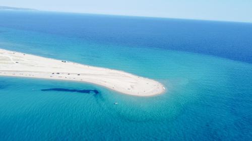 an aerial view of a white island in the ocean at The Olive Path in Kalandra