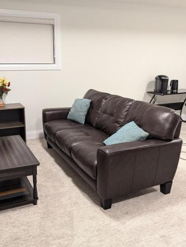 a brown leather couch in a living room at Spacious Luxury walk out Basement in Kitchener