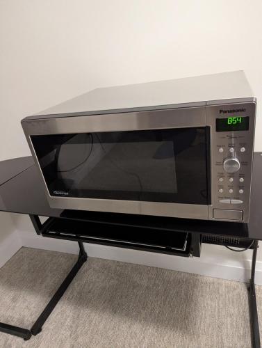 a microwave oven sitting on top of a stand at Spacious Luxury walk out Basement in Kitchener