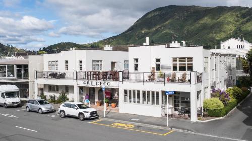 a white building with cars parked in front of it at The Signal - Stylish Deco Apt with Deck and Marina View in Picton