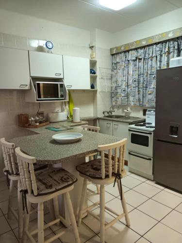 a kitchen with a table and chairs and a refrigerator at South Coast Riviera 203 in Port Shepstone