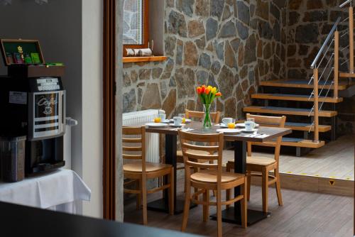 a dining room with a table and chairs with flowers on it at Penzion Snezienka in Tatranská Lomnica