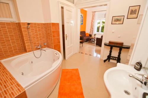 a bathroom with a tub and a sink at Apartman Isadora in Opatija