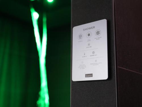 a remote control on a wall with a green background at WANDERLUST HOTEL - SUITE & SPA - APARTMENTS & VILLAS - Bardolino, Lago di Garda - Verona in Bardolino