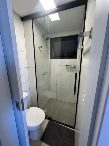 a bathroom with a toilet and a glass shower at Excellent apartment! Next to Mufato, McDonalds in Campo Largo