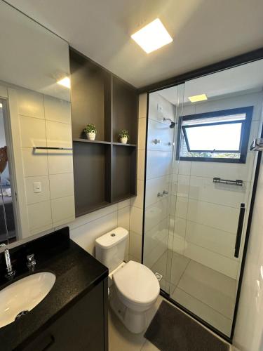 a bathroom with a toilet and a glass shower at Excellent apartment! Next to Mufato, McDonalds in Campo Largo