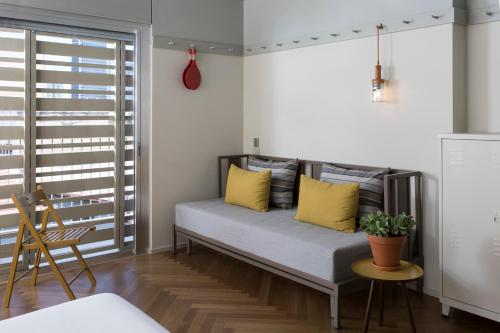 a couch in a room with yellow pillows on it at Florentin House - By HOMY in Tel Aviv