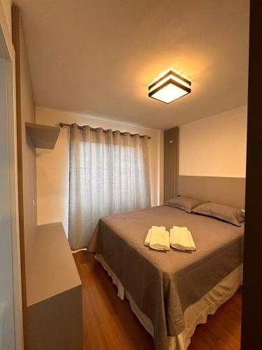 a bedroom with a bed with two towels on it at Excellent apartment! Next to Mufato, McDonalds in Campo Largo
