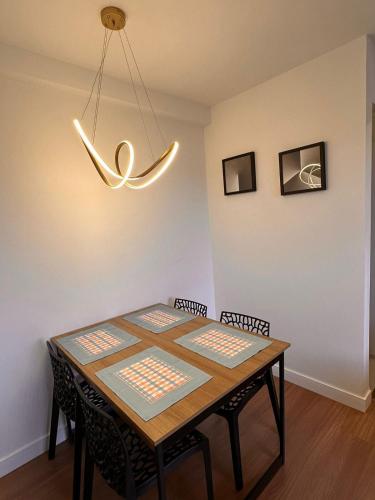 a dining room table with chairs and a light fixture at Excellent apartment! Next to Mufato, McDonalds in Campo Largo