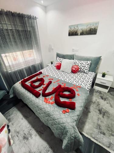 a bedroom with a bed with red letters on it at Motel Ječmište in Tuzla