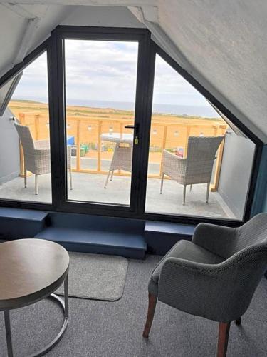 a room with a window with chairs and a table at The Dormy House Hotel in Cromer