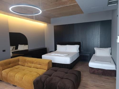 a hotel room with two beds and a couch at Toka Hotel Restaurant in Pogradec