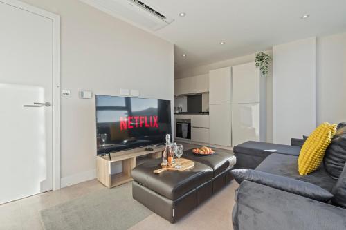 a living room with a couch and a tv at Family Apart for 6 Easy Booking in Sunbury Common